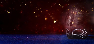 Image of elegant venetian mask over glitter background