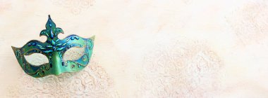 Holidays image of carnival party mask over white old vintage background. view from above