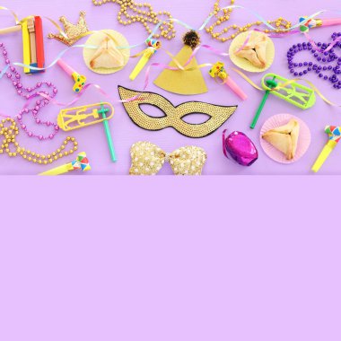 Purim kutlaması konsepti (Yahudi karnavalı tatili) ahşap mor arka planda. Üst manzara, düz uzanma