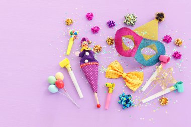 Mardi Gras 'nın maskeli pulların mor arkaplandaki resmi. Yukarıdan görünüm