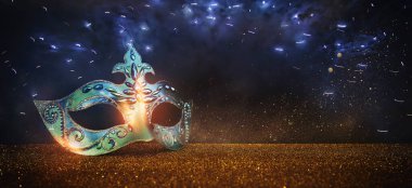 Image of elegant venetian mask over glitter background