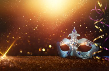 Image of elegant venetian mask over glitter background