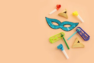 Purim celebration concept (jewish carnival holiday) over pastel background. Top view, flat lay