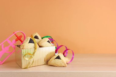 Purim bayramı konsepti (Yahudi karnavalı bayramı). Ahşap masanın üzerinde Hamantaschen kurabiyeleri