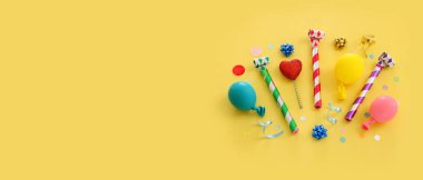 Top view image of party and present objects on yellow background