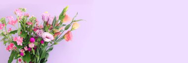 Top view image of pink and purple flowers composition over pastel background