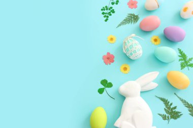 Cute bunny next to easter colorful eggs over blue pastel background