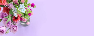 Top view image of pink and purple flowers composition over pastel background