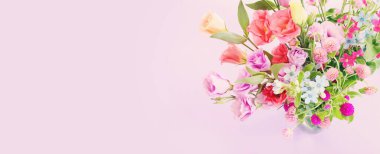 Top view image of pink and purple flowers composition over pastel background