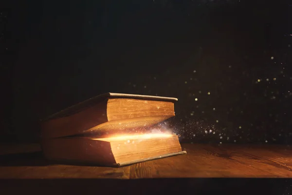 Kouzelný Obraz Otevřené Starožitné Knihy Nad Dřevěným Stolem Třpytivým Překrytím — Stock fotografie