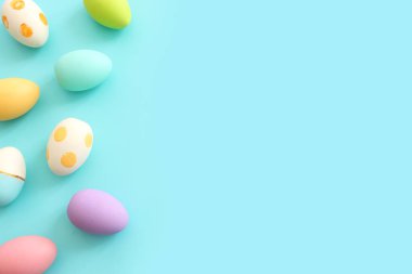 Top view of easter colorful eggs over pastel blue background