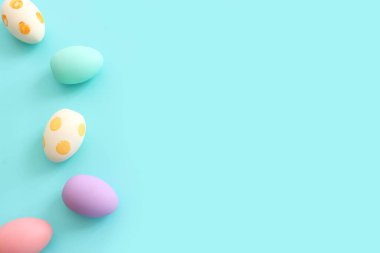 Top view of easter colorful eggs over pastel blue background