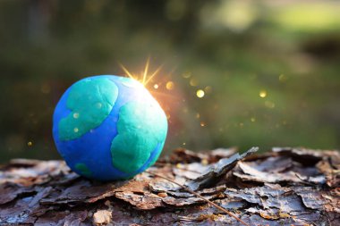 Ormandaki parlak güneş ışığıyla yeryüzünün modeli. Sürdürülebilirlik ve ekoloji kavramı
