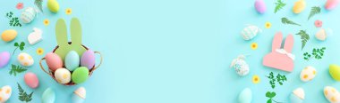 Cute bunny next to easter colorful eggs over blue pastel background