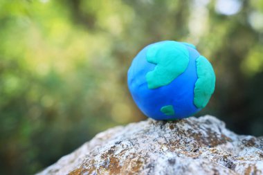 Ormandaki parlak güneş ışığıyla yeryüzünün modeli. Sürdürülebilirlik ve ekoloji kavramı