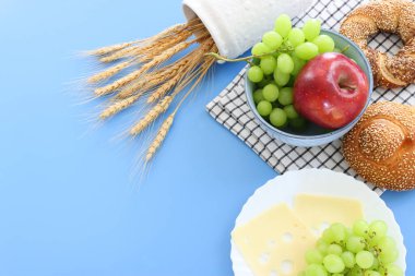 Ekmek ve süt ürünlerinin mavi arkaplanda fotoğrafı. Yahudi bayramının sembolleri - Shavuot