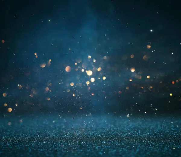 stock image background of abstract glitter lights. gold, blue and black. de focused