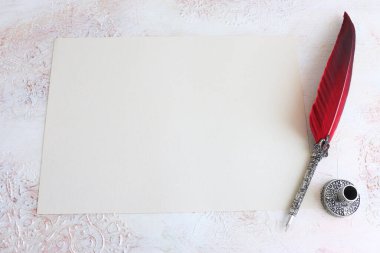 Kırmızı tüy ve boş kağıt ile klasik mürekkep kalemi