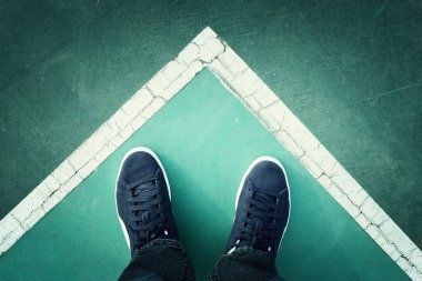 Asfalt yoldaki spor ayakkabıları, ilerleyen adam.