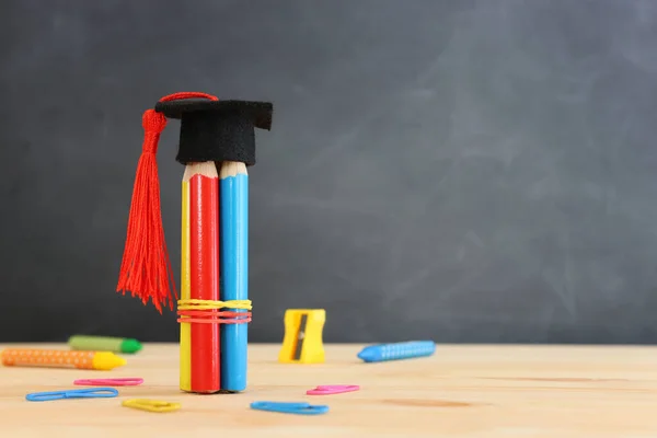 Bleistifte Und Graduiertenmütze Vor Dem Hintergrund Der Tafel Bildungskonzept — Stockfoto