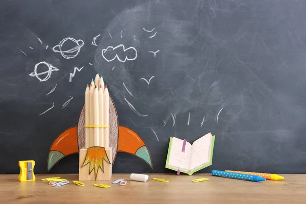 学校コンセプトに戻る 教室のブラックボードの上に ロケットと鉛筆 トップビュー — ストック写真