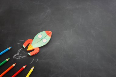 Okul konseptine geri dönelim. Sınıfın tahtasında roket ve kalem var. Üst görünüm