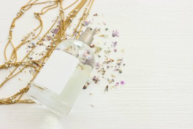 Ahşap beyaz arka planda temiz, zarif bir parfüm şişesi resmi