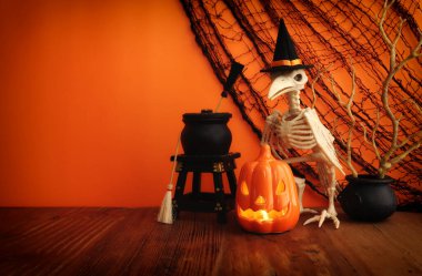 Cadılar Bayramı 'nın resmi. balkabağı ve kuş iskeleti ahşap masanın üzerinde