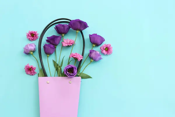パステルブルーの背景にピンクと紫の花の構図のトップビューのイメージ フラットレイ — ストック写真