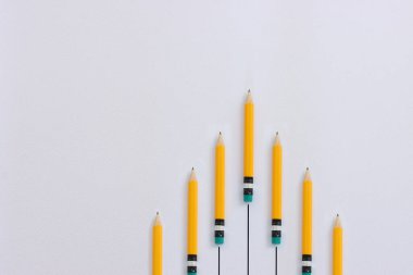 Beyaz desenli kağıt üzerindeki kalemlerin üst görünümü