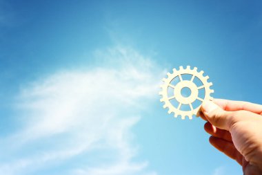 Gökyüzünün önünde el dönen dişliler