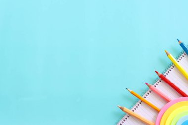 Eğitim ve okul konseptine geri dönüş. Kırtasiye malzemesi mavi arka planda. Üst görünüm, düz uzanma