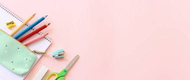 Eğitim ve okul konseptine geri dönüş. Pembe arka planda kırtasiye malzemesi. Üst görünüm, düz uzanma