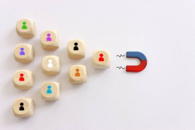 Bir grup insanı çeken bir mıknatıs görüntüsü. Medya etkisi ve insan kaynakları metaforu