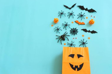 Cadılar Bayramı 'nın resmi. turuncu kağıt çanta, örümcekler ve yarasalar mavi arka planda
