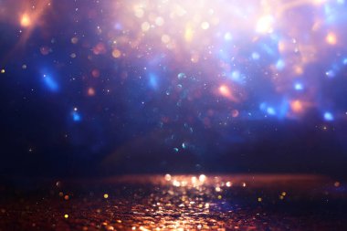 Soyut simli siyah, mavi ve altın renkli ışıklar arka planda. Odaklanmamış