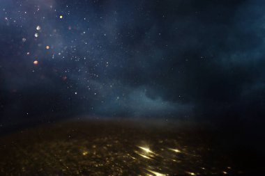 Soyut parıltılı ışıkların arkaplanı. Altın, mavi ve siyah. & Odaklan