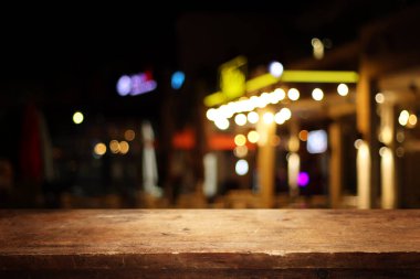 Soyut bulanık restoran ışıklarının önündeki ahşap masanın arkaplan resmi