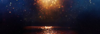 Soyut simli siyah, altın rengi, mavi ışıklı arka plan. Odaklanmamış