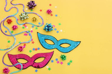 Sarı arka planda maskeli maskelerin tatil görüntüleri. Yukarıdan görünüm