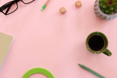 Masanın nesneler, kahve, bardaklar ve ofis malzemeleriyle üst görünümü