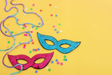 Sarı arka planda maskeli maskelerin tatil görüntüleri. Yukarıdan görünüm
