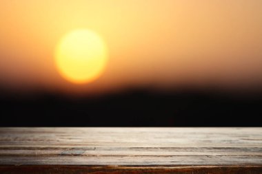 Gün batımının önündeki boş köy masası. ürün gösterimi ve piknik konsepti