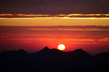Gün batımında dağların üzerinde bulutlar