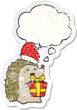 Düşünce baloncuklu Noel şapkası takan bir kirpi çizgi film karakteri insan tarafından çizilmiş yıpranmış bir çıkartma.