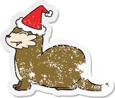 Gülen su samuru eli, bir insan tarafından çizilmiş Noel Baba şapkasının üzgün çıkartması çizilmiş.