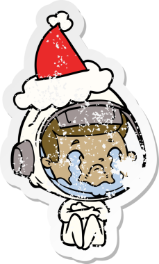 Bir insan tarafından çizilmiş Noel Baba şapkası giymiş ağlayan bir astronotun el çizimi.
