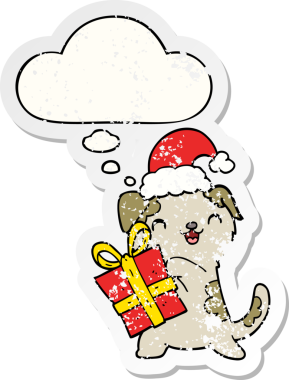 Noel hediyesi olan şirin bir çizgi film köpeği ve insan tarafından çizilmiş yıpranmış bir çıkartma gibi düşünce baloncuklu bir şapka.