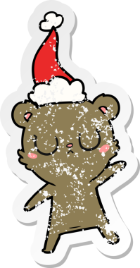 Huzurlu bir el, bir insan tarafından çizilmiş Noel Baba şapkası takan bir ayı çıkartması çizmiş.