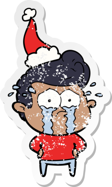Bir insan tarafından çizilmiş, ağlayan, Noel Baba şapkası takan, kederli bir adamın çıkartması.
